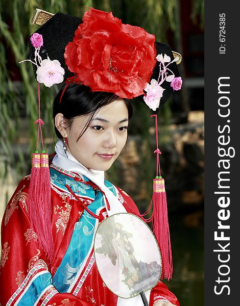 A beautiful girl in Chinese ancient dress is in the royal garden. This is dress of Qing Dynasty of China. It is the princess' dress too. Chinese on the fan is meant and missed. A beautiful girl in Chinese ancient dress is in the royal garden. This is dress of Qing Dynasty of China. It is the princess' dress too. Chinese on the fan is meant and missed.