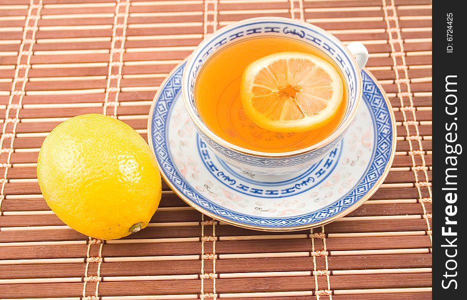 Fragrant tasty useful tea with lemon cup with blue figure on napkin strip