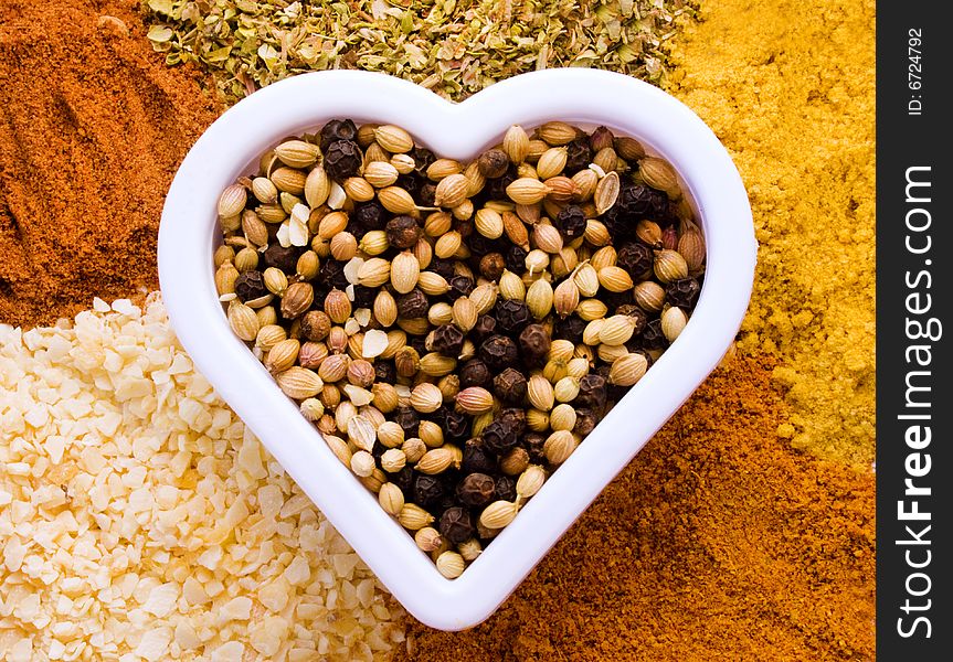 Heart shape filled and surrounded by variety of spices. Heart shape filled and surrounded by variety of spices