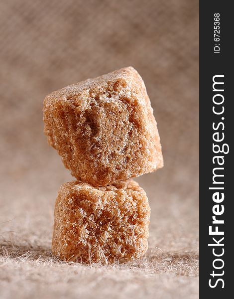 Two brown sugar cubes on hessian background, macro, shallow DOF