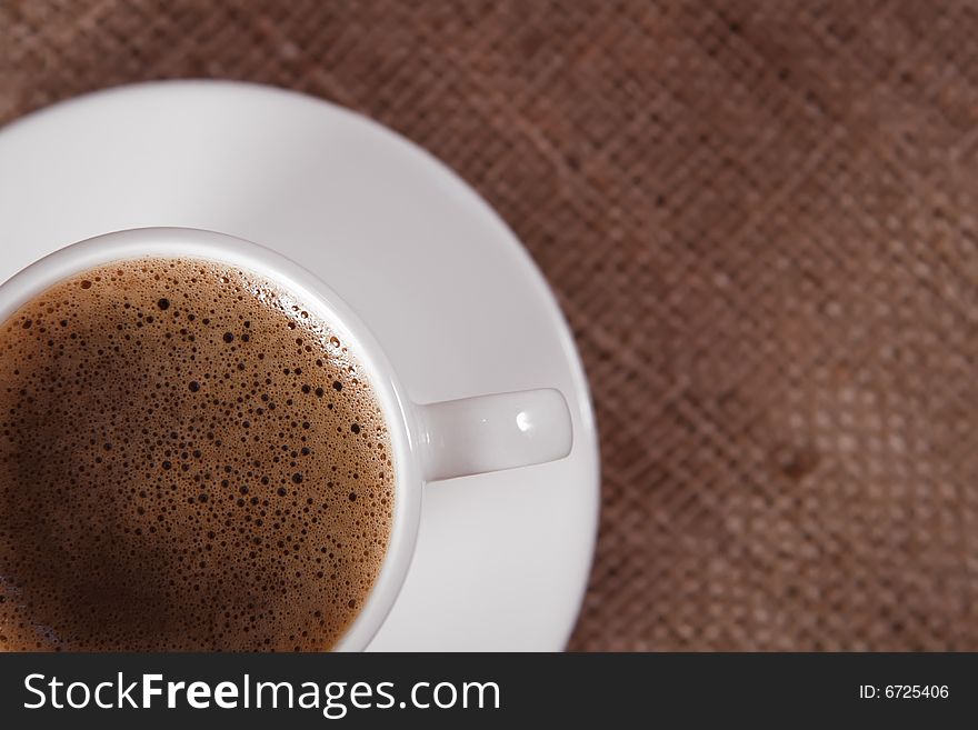 Closeup of  black coffee cup on hessian background, shallow DOF