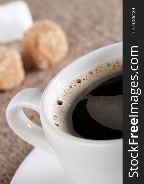 Delicious Black Coffee in white cup, sugar cubes and hessian background, shallow DOF. Delicious Black Coffee in white cup, sugar cubes and hessian background, shallow DOF