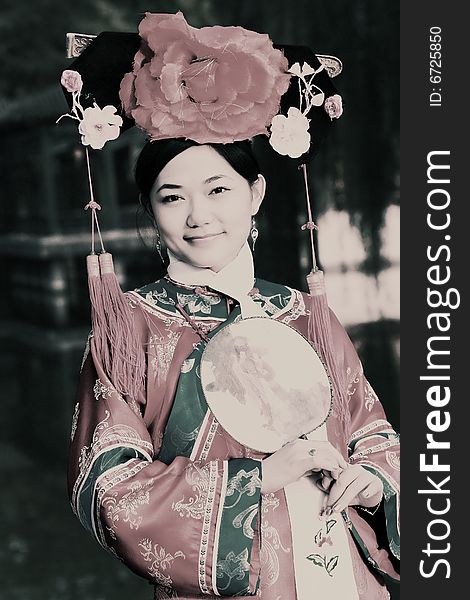 Portrait of a beautiful girl in Chinese ancient dress. 
Chinese on the fan is meant and missed. Portrait of a beautiful girl in Chinese ancient dress. 
Chinese on the fan is meant and missed.