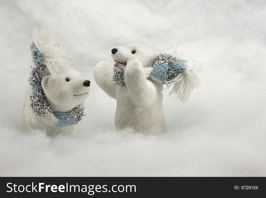 Pair of Polar Bear ornaments with wool scarves tied around their necks against a snow background. Pair of Polar Bear ornaments with wool scarves tied around their necks against a snow background.