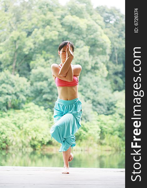 Young Chinese Woman Practicing Yoga Outdoor