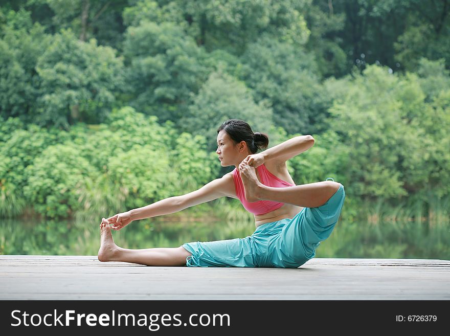 Young chinese woman practicing yoga outdoor