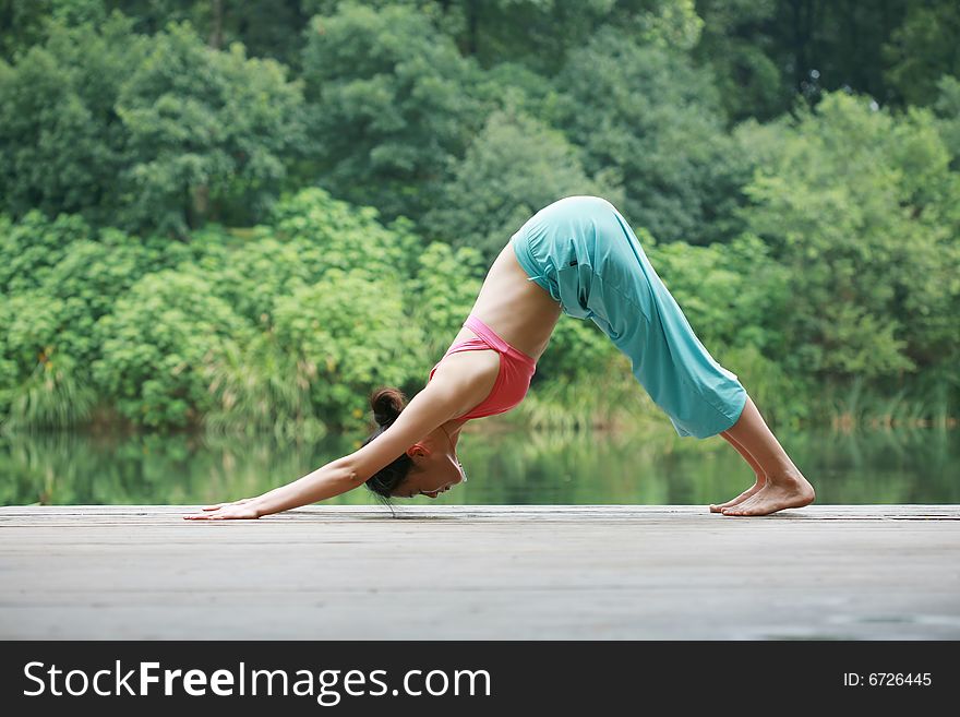 A young chinese woman practicing yoga in the outdoors. A young chinese woman practicing yoga in the outdoors