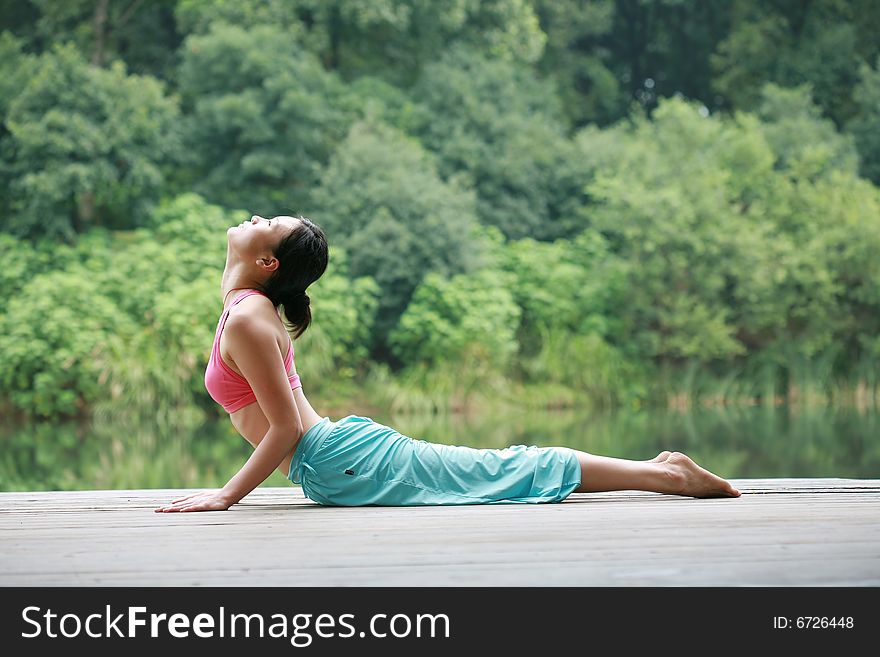 Young chinese woman practicing yoga outdoor