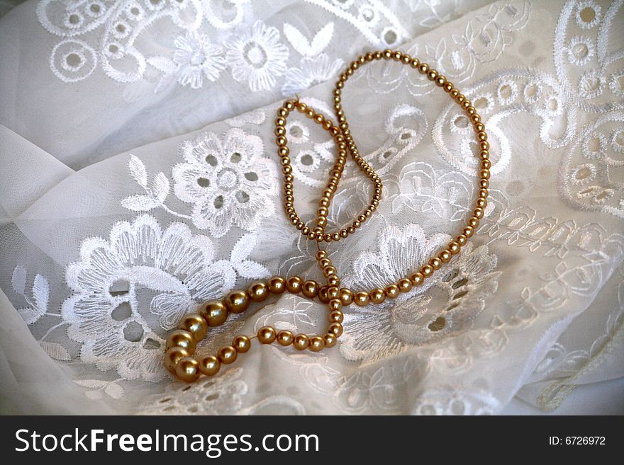 Pearl necklace on embroidered fabric