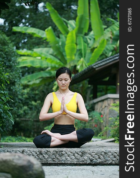 A young chinese woman practicing yoga in the outdoors. A young chinese woman practicing yoga in the outdoors