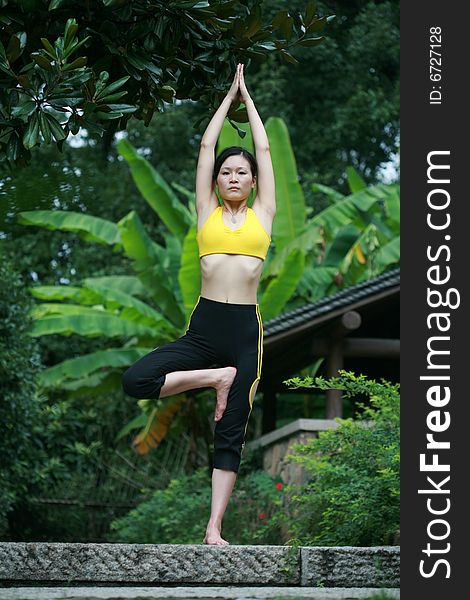 A young chinese woman practicing yoga in the outdoors. A young chinese woman practicing yoga in the outdoors