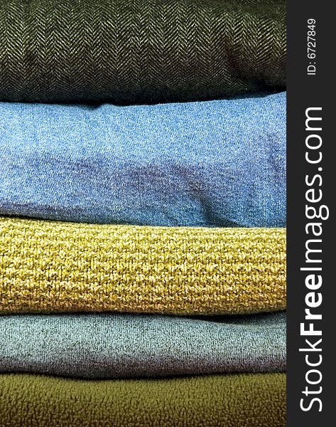 Vertically oriented stacks of various fabrics in neutral colors. Vertically oriented stacks of various fabrics in neutral colors.