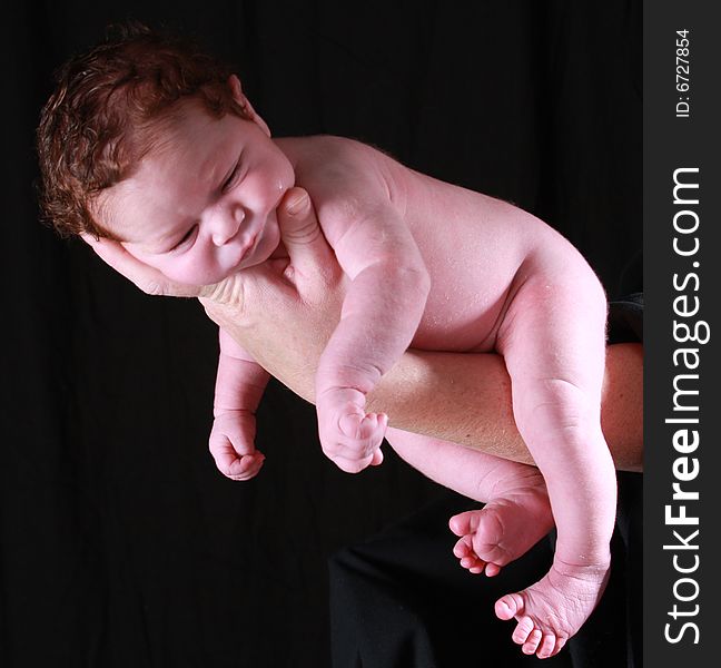 Little baby with a head full of hair on mommy's hand. Little baby with a head full of hair on mommy's hand