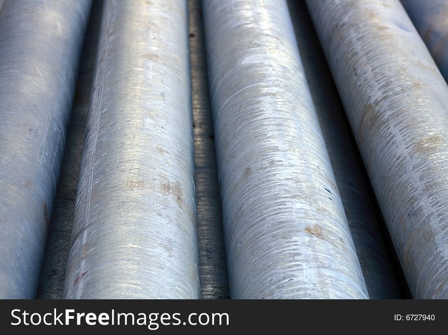 Background with lying gray drain pipes for pipeline