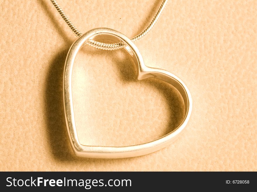 A hearts with Silvers and necklace isolated on the tint yellow. A hearts with Silvers and necklace isolated on the tint yellow