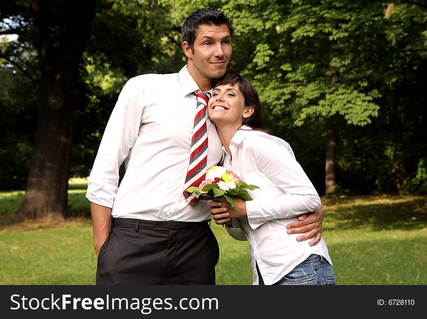 Woman and man in arms with bouquet of flowers. Woman and man in arms with bouquet of flowers