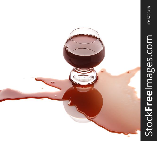 The spilled red wine. Wine poured on a surface, is isolated on a white background