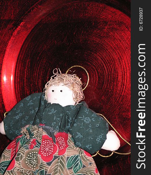 Christmas doll on a bright red plate