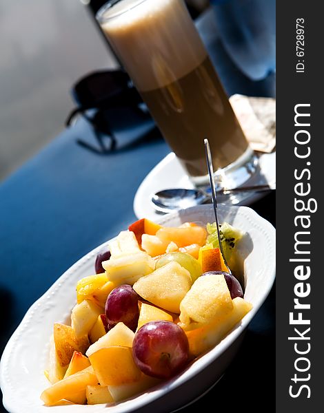 Fruit salad and coffee latte outdoors. Fruit salad and coffee latte outdoors