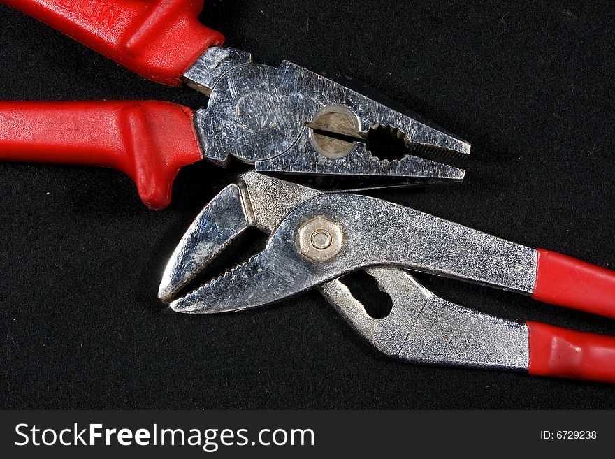 Pliers with red neck on a black background. Pliers with red neck on a black background