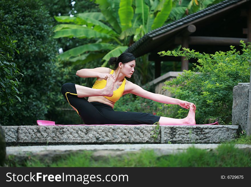 A young chinese woman practicing yoga in the outdoors. A young chinese woman practicing yoga in the outdoors