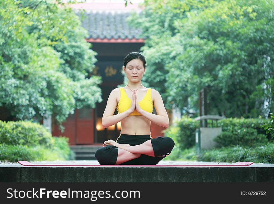 A young chinese woman practicing yoga in the outdoors. A young chinese woman practicing yoga in the outdoors