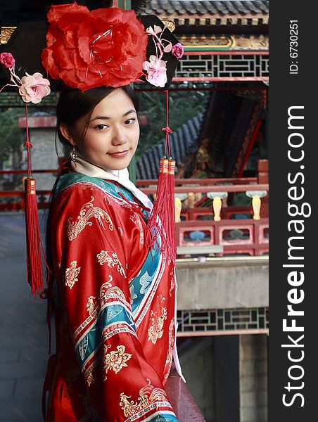 A girl in Chinese ancient dress stands in the attic in the royal garden. A girl in Chinese ancient dress stands in the attic in the royal garden.