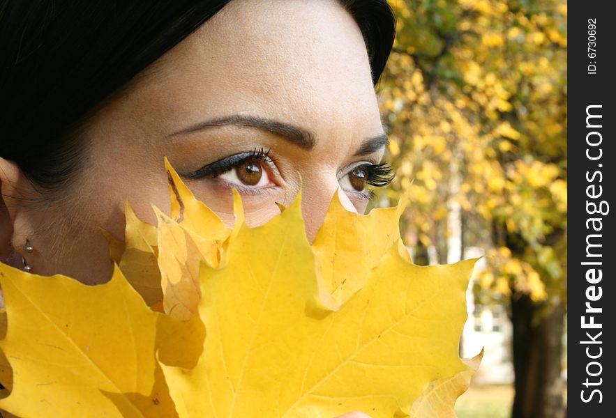 The girls closes her face with leaves. The girls closes her face with leaves