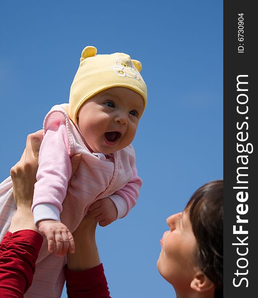 Baby with mom on blue sky background