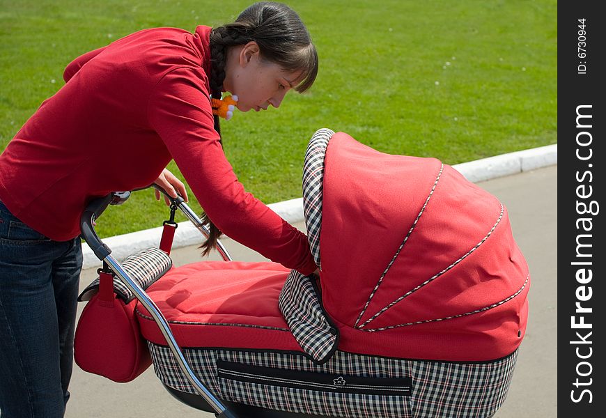 Young woman with red baby carriage. Young woman with red baby carriage