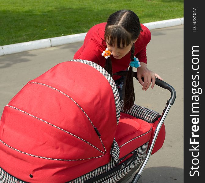 Young woman with red baby carriage. Young woman with red baby carriage