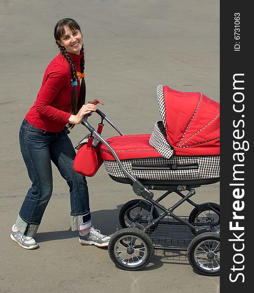 Young woman with red baby carriage. Young woman with red baby carriage