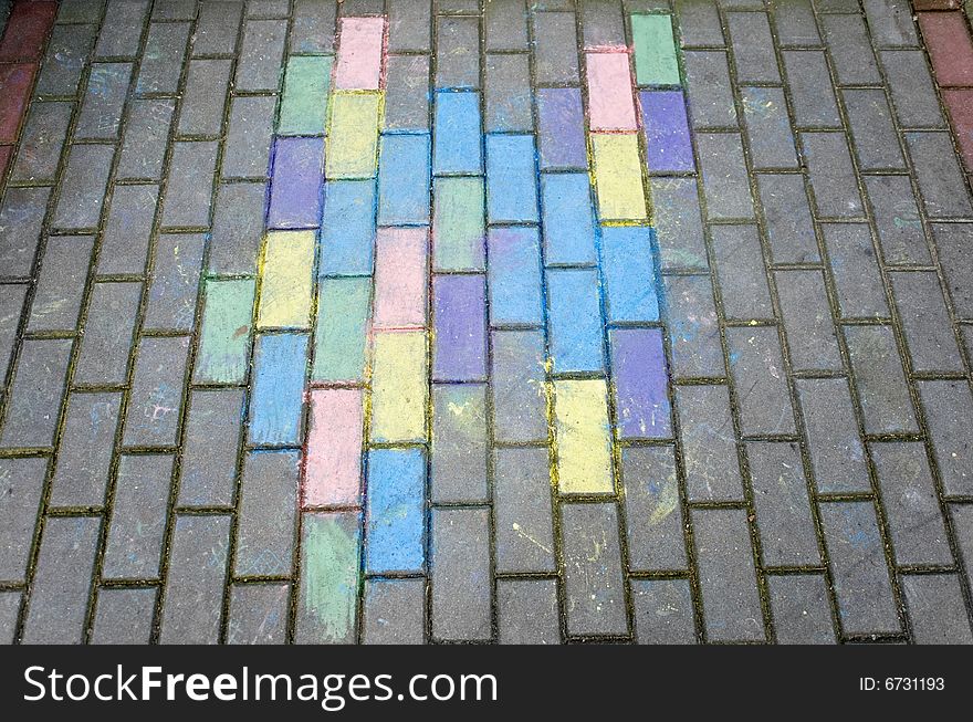 Perspective view of colorful kid's chalk drawing on pavement bricks