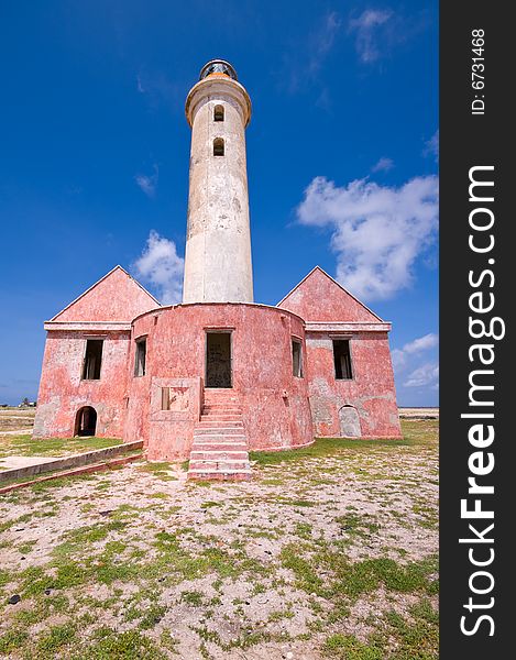 Ancient lighthouse ruin on little curacao against blue cloudy sky