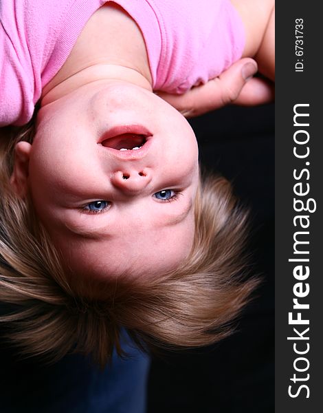 A sweet little girl hangs upside down and checks out life. A sweet little girl hangs upside down and checks out life.