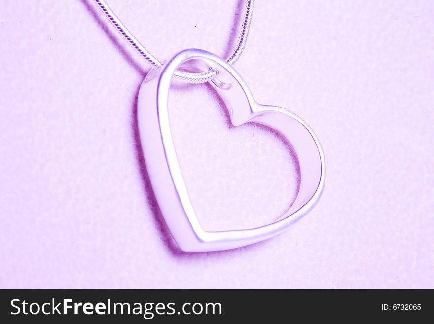 A hearts with Silvers and necklace isolated on the tint pink. A hearts with Silvers and necklace isolated on the tint pink