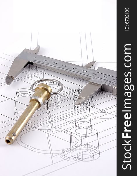 A pip-pin and calipers on a technical drawing with selective focus