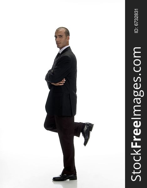 Young businessman standing on one leg with white background