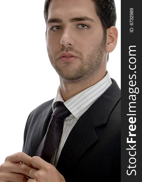 Businessman holding tie and looking to camera on an isolated white background