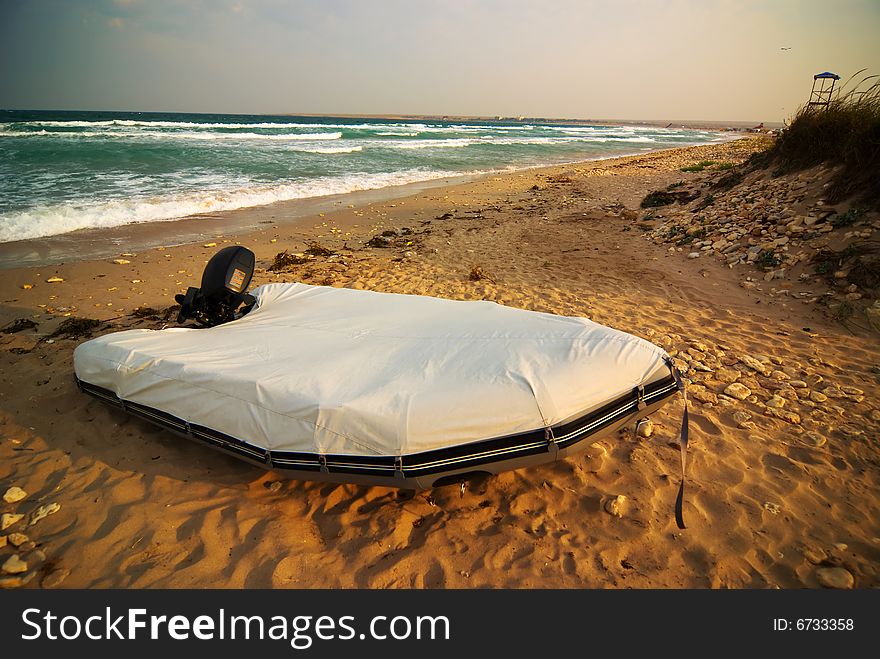 Emergency outboard motor boat on the emty beach during storm. Emergency outboard motor boat on the emty beach during storm