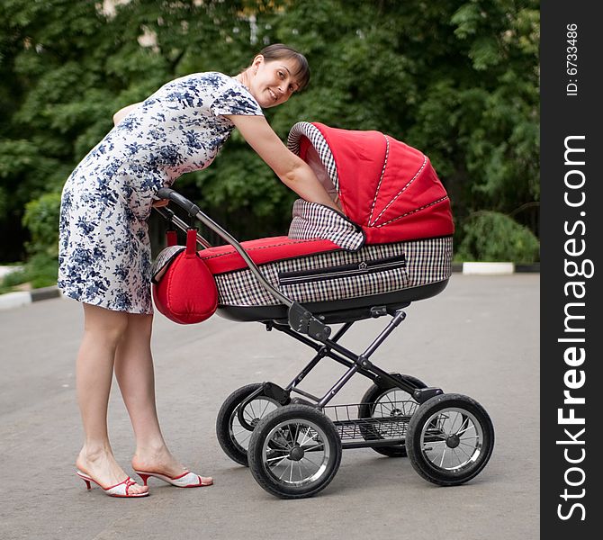 Young woman with red baby carriage. Young woman with red baby carriage