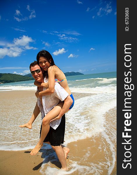 Portrait of a happy young couple having fun on the beach. Couple enjoying a summer vacation. Portrait of a happy young couple having fun on the beach. Couple enjoying a summer vacation.