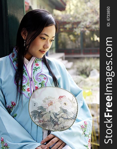 A beautiful girl in Chinese ancient dress is in the royal garden. 

This is dress of Ming Dynasty of China.

Chinese on the fan is peony. A beautiful girl in Chinese ancient dress is in the royal garden. 

This is dress of Ming Dynasty of China.

Chinese on the fan is peony.