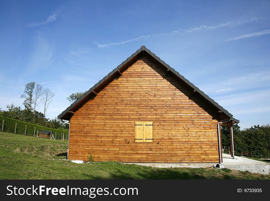 Wooden chalet in green garden and blue sky, Correze, France. Wooden chalet in green garden and blue sky, Correze, France