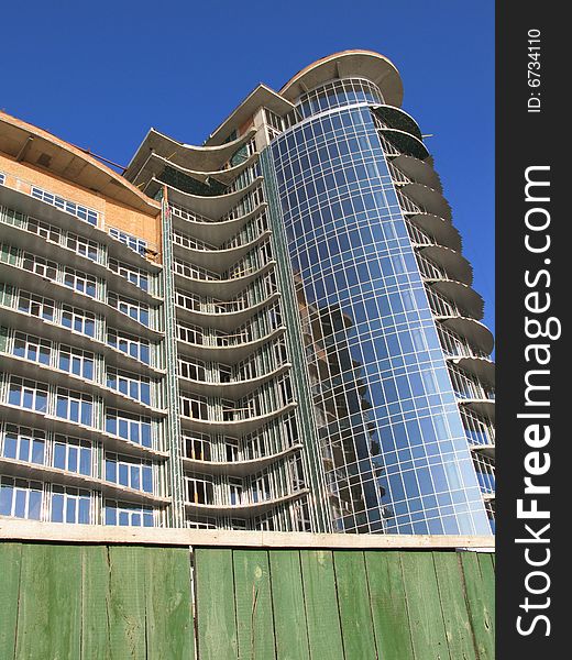 The modern house is Built. He sparkles all window under sun, on background blue sky. The modern house is Built. He sparkles all window under sun, on background blue sky.