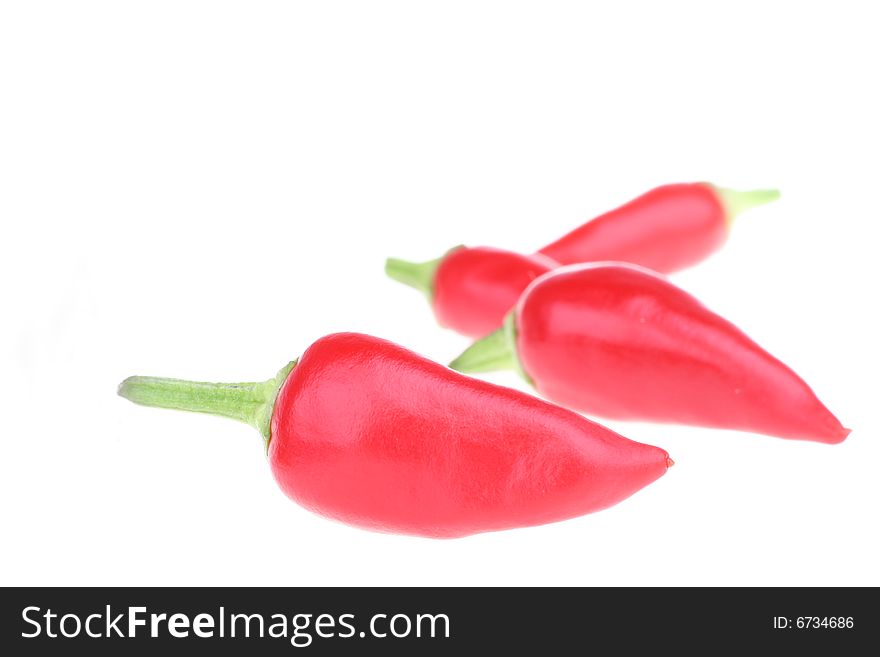 Four red chili peppers isolated on a white background.