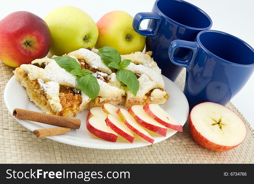 Apple pie on the plate with apples in the background