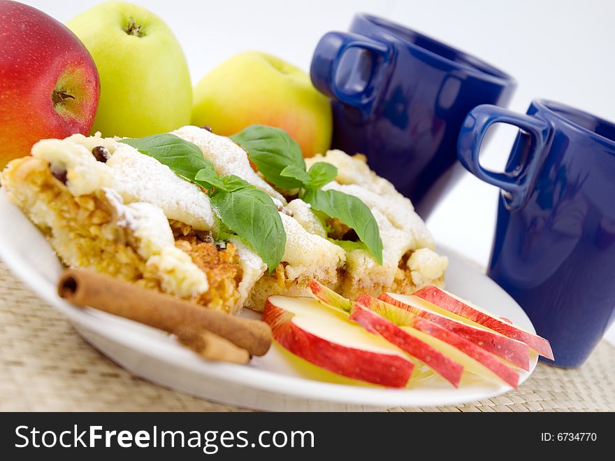 Apple pie on the plate with apples in the background