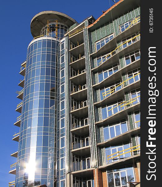 The modern house is Built. He sparkles all window under sun, on background blue sky. The modern house is Built. He sparkles all window under sun, on background blue sky.