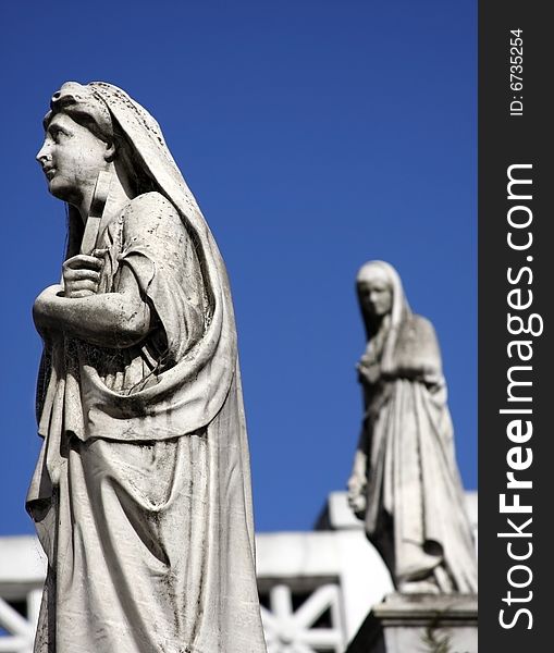 Religious statues from Recoleta Cemetery, Buenos Aires, Argentina. Focus on the statue at the front, shallow dof.